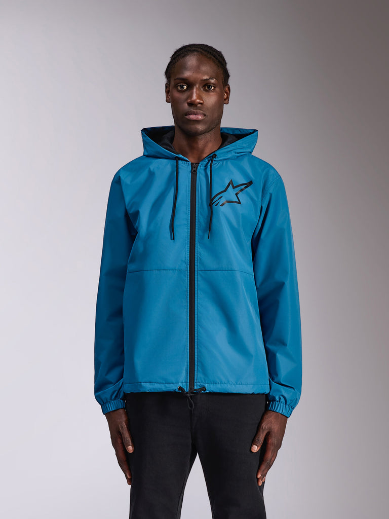 Alpinestars Speeder Chromium Windbreak Jacket, Blue hooded windbreaker with black Astars logo on the chest, full-length front zipper, elastic cuffs and drawstring hood, worn by a model as casual sportswear.