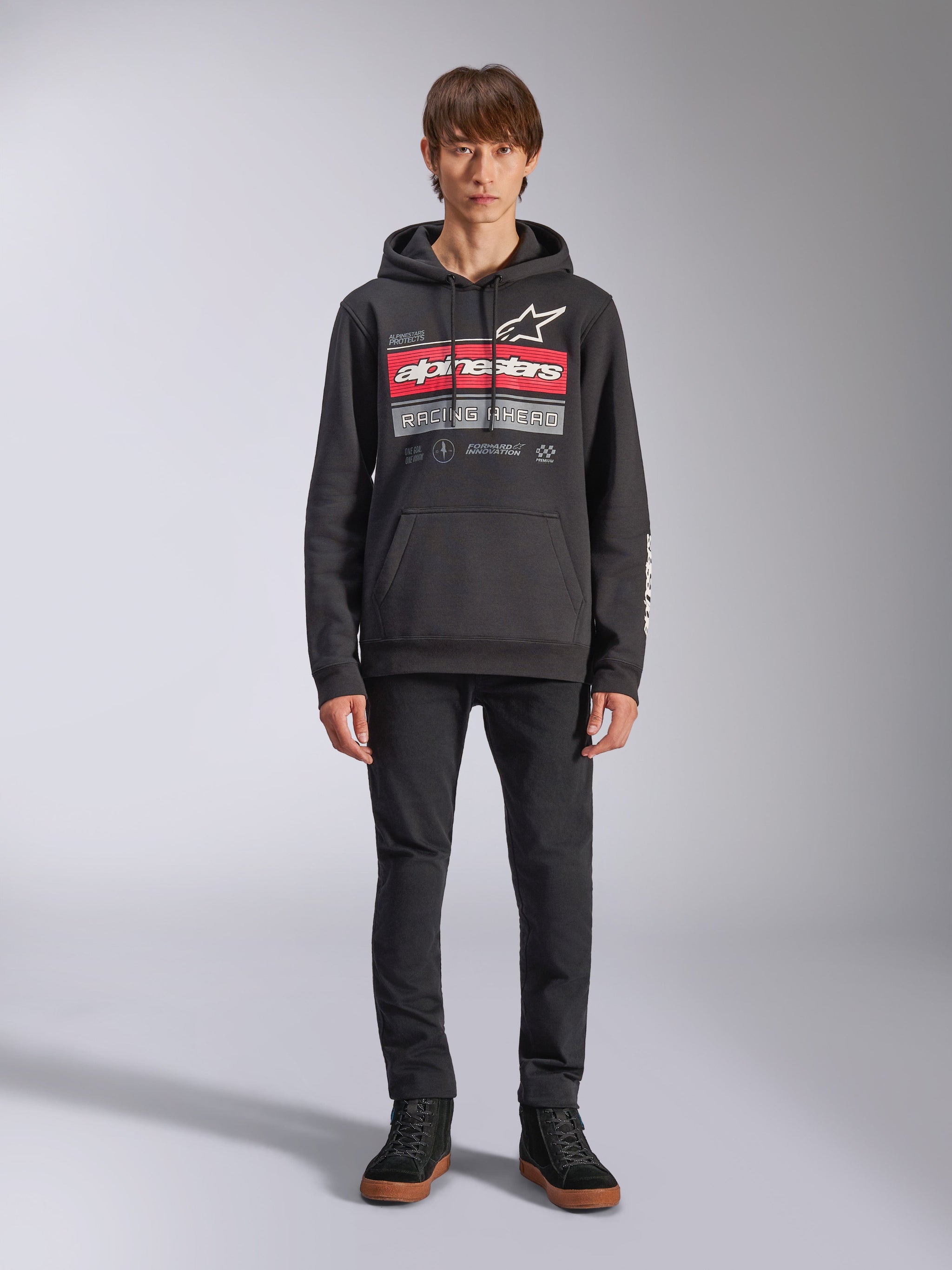 Alpinestars Harken Hoodie, Black Pullover Hoodie, bold chest graphic with red stripes and 'Racing Ahead' text, white Astars logo, kangaroo pocket, drawstring hood, casual motorsport-inspired streetwear