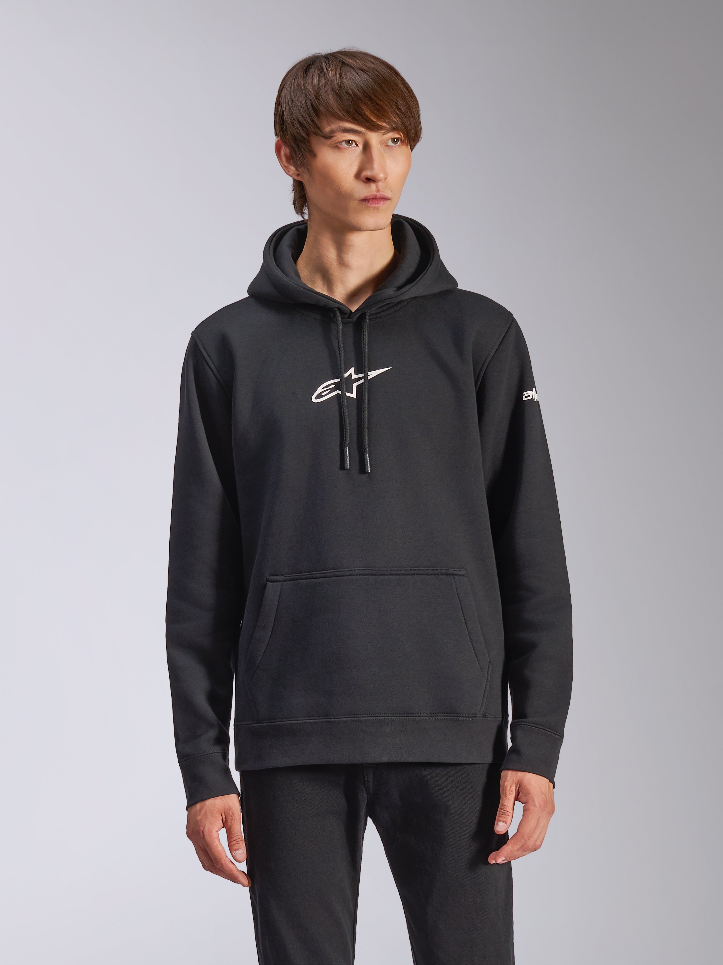 Alpinestars Frontal Hoodie, svart pullover-huvtröja i fleece, vit Alpinestars-logotyp på bröstet, vit ordmärkeslogotyp på ärmen, känguruficka, avslappnad motorsport-streetwear