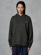 Alpinestars Essentials Ageless Hoodie, Off Black, bärs av en modell, med en liten vit Astars-logotyp på bröstet, känguruficka fram, stentvättad finish, avslappnad premium fleece-streetwear
