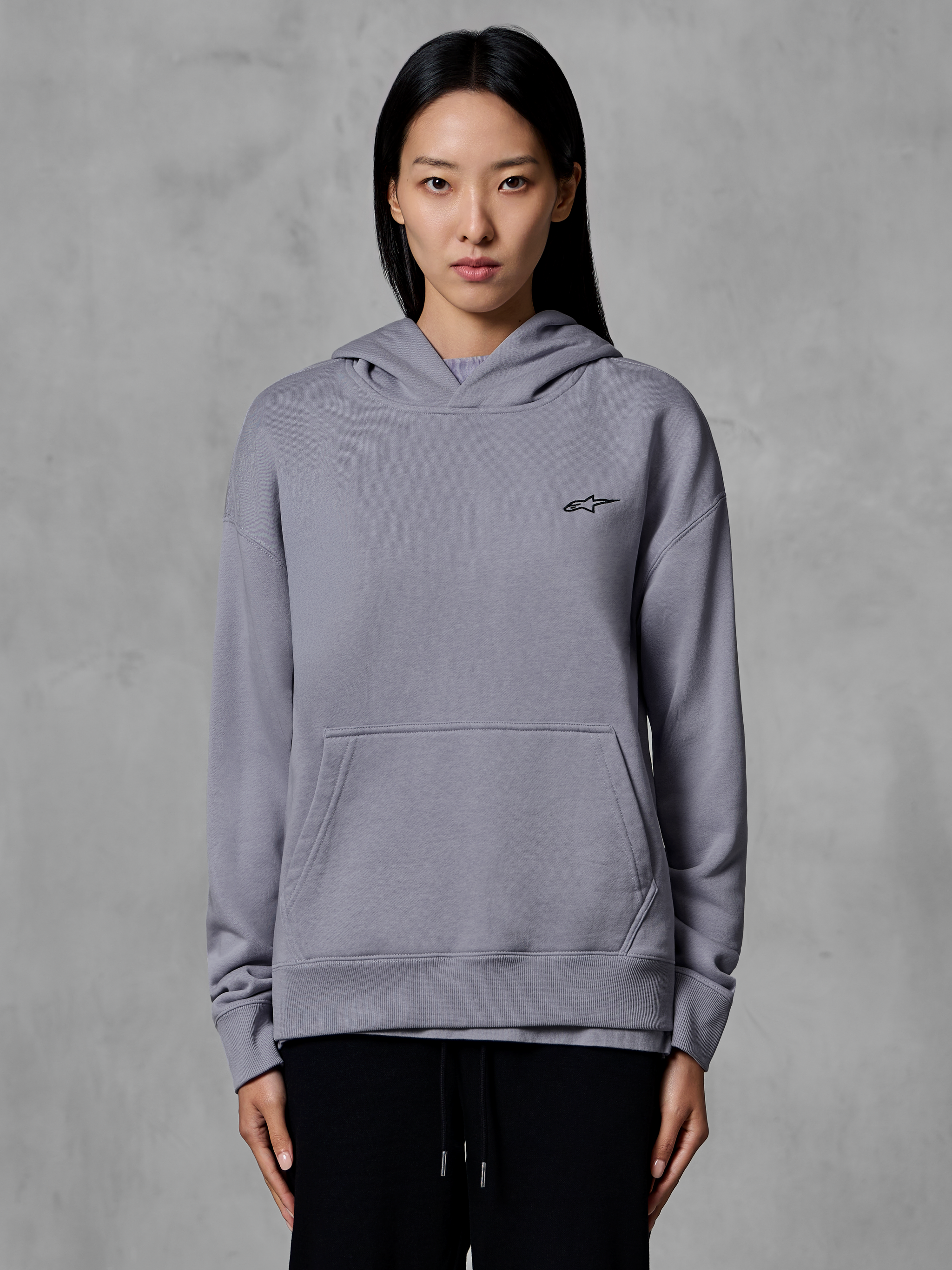 Alpinestars Essentials Ageless Hoodie, vardagliga sportkläder, silverfärgad med en liten svart logotyp, känguruficka, huvtröja buren av modell, moderna livsstilskläder