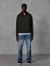 Alpinestars Essentials Ageless Zip Hoodie, huvtröja med hel dragkedja, Off Black, med en liten vit Alpinestars-logotyp på bröstet, bärs av en modell med en vit t-shirt och blå jeans, avslappnad passform, casual motorsport-streetwear