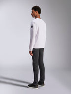 Alpinestars Bettern Crew, vit sweatshirt med rund halsringning, bak- och sidovy, svart rund logotyp på ärmen, bärs med mörkgrå byxor och svarta sneakers, avslappnad motorsport-streetwear