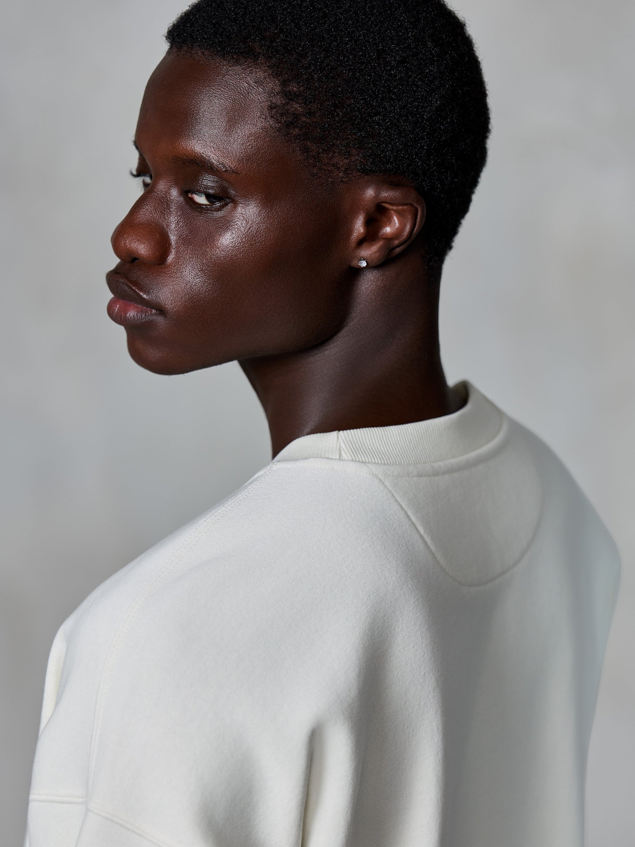 Alpinestars Essentials Ageless Crew, crewneck-tröja, Off White, närbild bakifrån på modell som visar den ribbade halsringningen och premium fleece-textur, avslappnad livsstils-streetwear