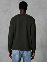 Alpinestars Essentials Ageless LS Tee, långärmad t-shirt, Off Black, baksida som visar en ren design och avslappnad passform, bärs av modell med blå jeans, avslappnad motorsport-inspirerad streetwear