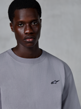 Alpinestars Essentials Ageless SS Tee, kortärmad t-shirt, silver, med en liten svart stjärnlogotyp på bröstet, bärs av modell, vardaglig lifestyle-streetwear