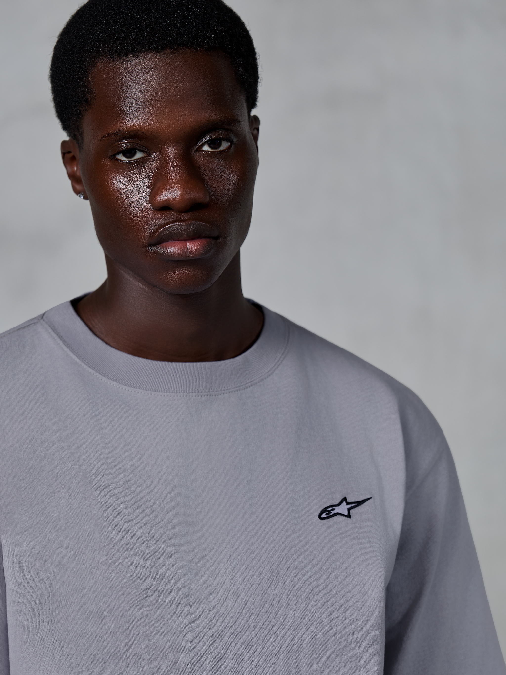 Alpinestars Essentials Ageless SS Tee, kortärmad t-shirt, silver, med en liten svart stjärnlogotyp på bröstet, bärs av modell, vardaglig lifestyle-streetwear