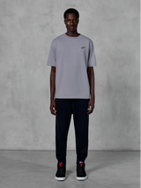 Alpinestars Essentials Ageless SS Tee, kortärmad t-shirt, silver, med en liten svart logotyp på bröstet, stylad med svarta joggers och sneakers, avslappnad motorsport-streetwear