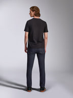 Alpinestars Global CSF T-shirt, kortärmad tröja i svart, ryggvy av manlig modell som bär t-shirten med mörka jeans, avslappnat motorsportinspirerat streetwear