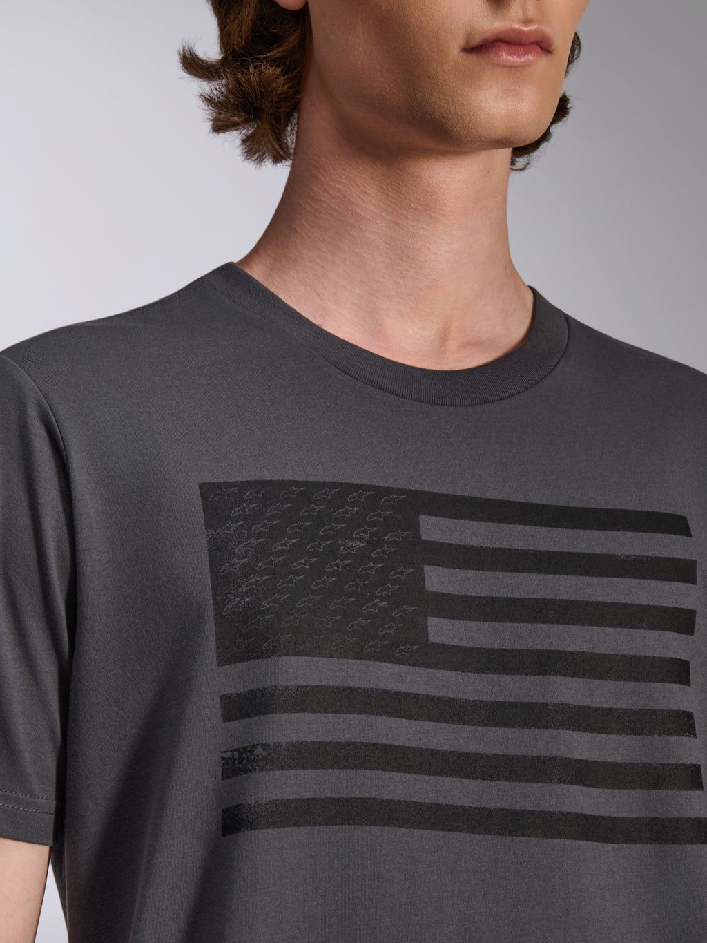 Alpinestars Waving CSF Tee, kortärmad t-shirt, charcoal, med en svart flaggrafik med stjärnlogotyper på bröstet, avslappnad motorsport-streetwear