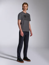 Alpinestars Waving CSF Tee, Short Sleeve T-Shirt, Charcoal, Black Waving Flag Graphic, worn by a model with dark jeans and sneakers, Casual Motorsport Streetwear