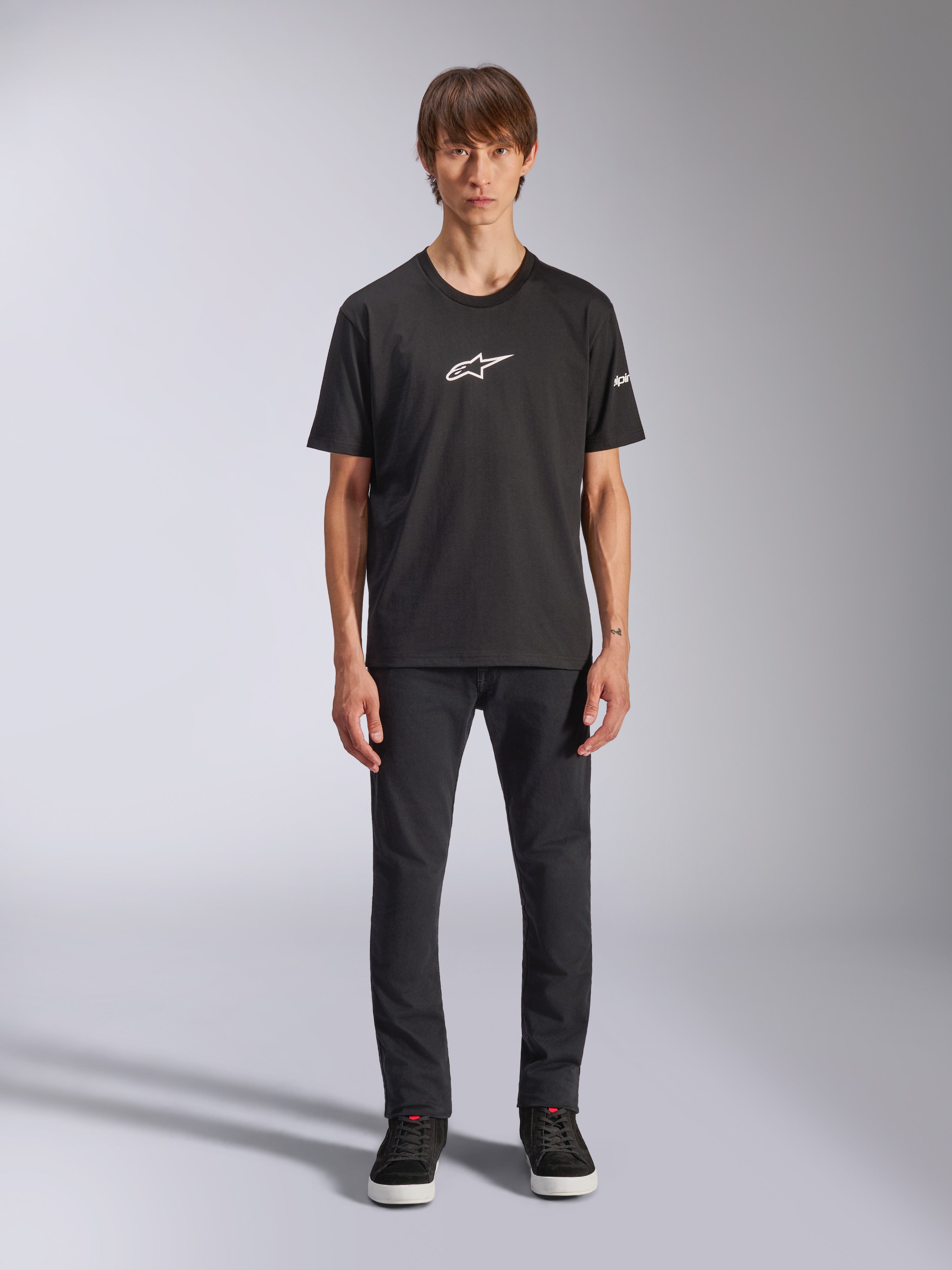 Alpinestars Frontal CSF Tee, kortärmad t-shirt, svart, vit Alpinestars-logotyp på bröstet, bärs av modell med svarta byxor och svarta skor, funktionella vardagskläder