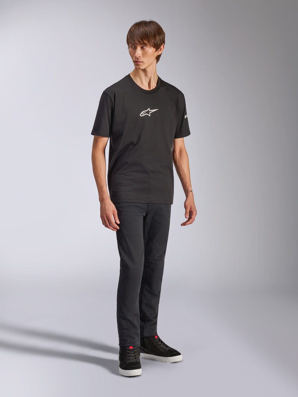 Alpinestars Frontal CSF T-shirt, kortärmad t-shirt, svart, vit Astars-logotyp på bröstet, bärs av en modell med mörka jeans och svarta sneakers, avslappnad streetwear med prestanda