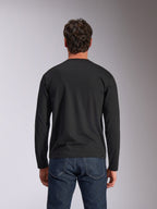 Alpinestars Trackside CSF Tee, långärmad t-shirt, svart, baksida, bärs med mörkblå denimjeans, avslappnat motorsportinspirerat streetwear