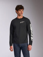 Alpinestars Trackside CSF långärmad t-shirt, svart, vit Alpinestars-logotyp på bröstet och märkning på ärmen, bärs av en modell med blå jeans, avslappnad motorsport-streetwear
