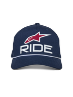 Alpinestars Ride Comp Snapback keps, marinblå med vita och röda detaljer, med en RIDE-logotyp i 3D, rött stjärnemblem och vit flätad repkant, böjd skärm, vardaglig motorsport-huvudbonad
