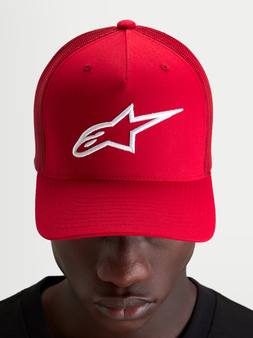 Alpinestars Ageless Snapback keps, röd och vit med broderad Astars-logotyp, strukturerad krona och böjd skärm, bärs av en modell