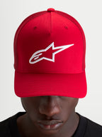 Alpinestars Ageless Snapback keps, röd och vit med broderad Astars-logotyp, strukturerad krona och böjd skärm, bärs av en modell