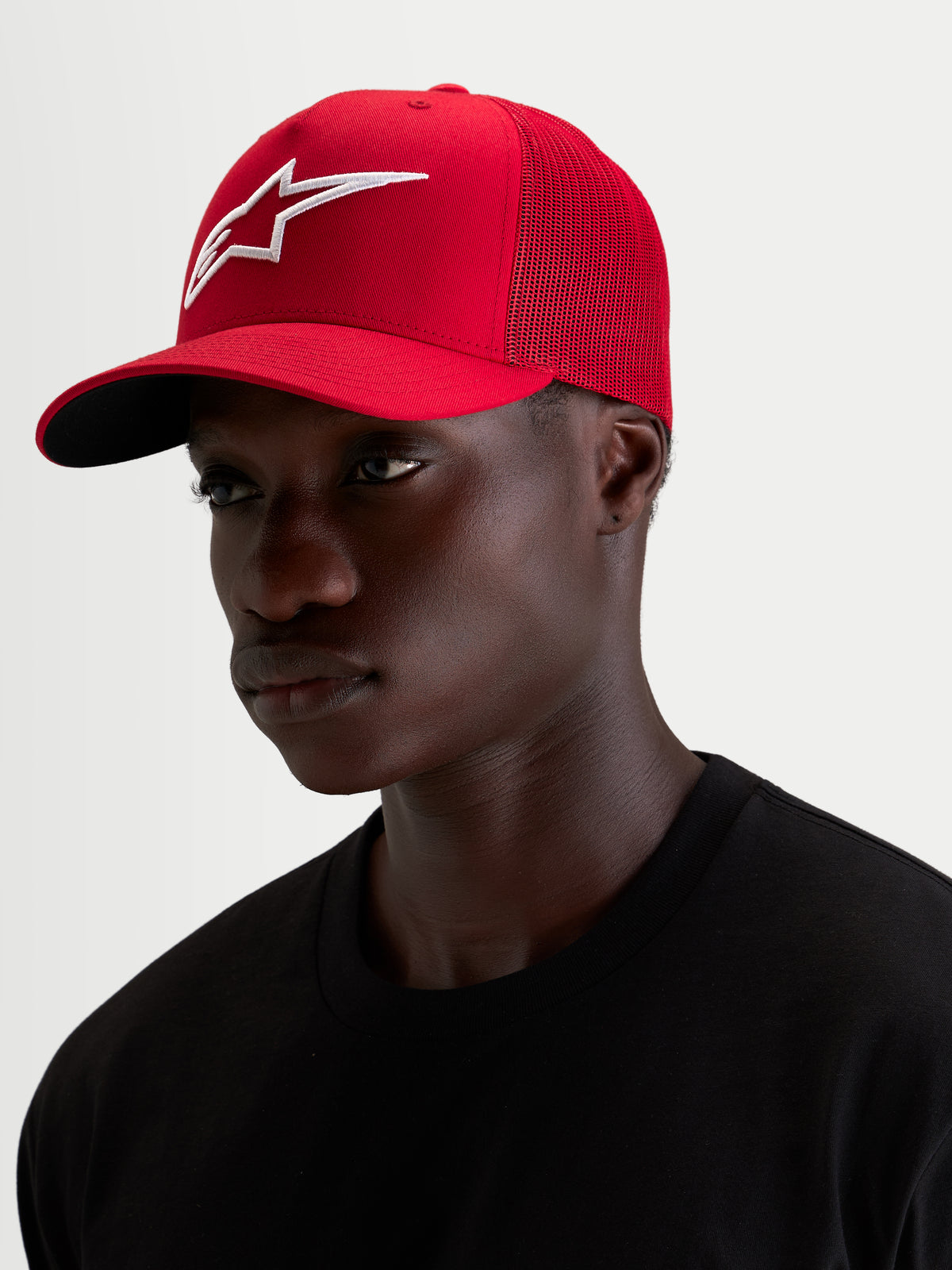 Alpinestars Ageless Snapback keps, röd sportkeps med en framträdande broderad 3D-Astars-logotyp och böjd skärm, bars av en modell