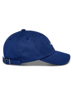 Alpinestars Deduce Strapback Keps, blå, sidoprofil, böjd skärm, justerbar remknäppning med mässingsspänne, konstruktion i bomullstwill, vardaglig huvudbonad med vitt broderad logotyp