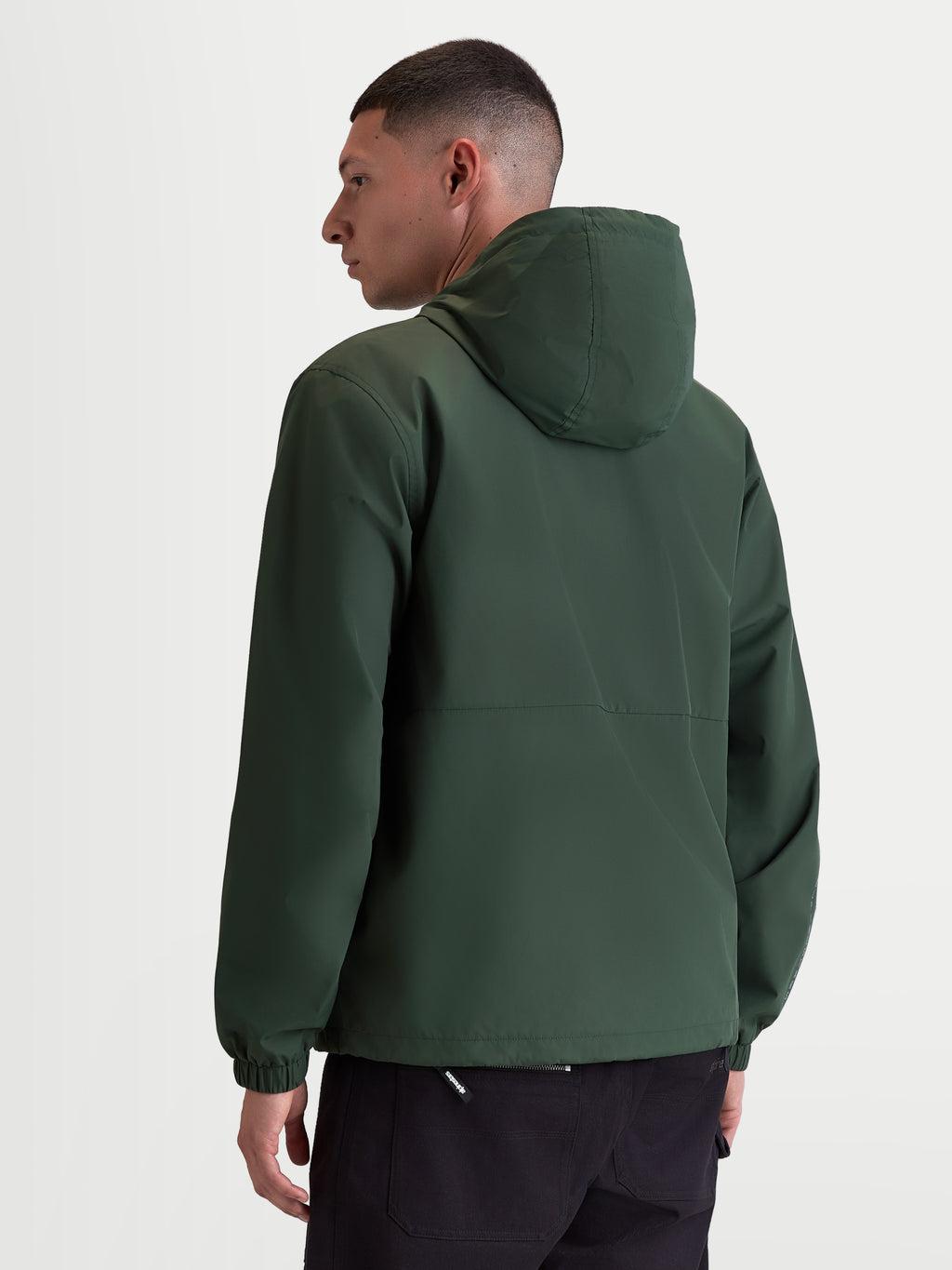 Alpinestars Speeder Resolve vindstoppsjacka, lätt sportjacka för urban användning, grön, vindtät polyester med meshfoder, baksida på modell som visar den rena ryggdesignen och elastiska muddar.