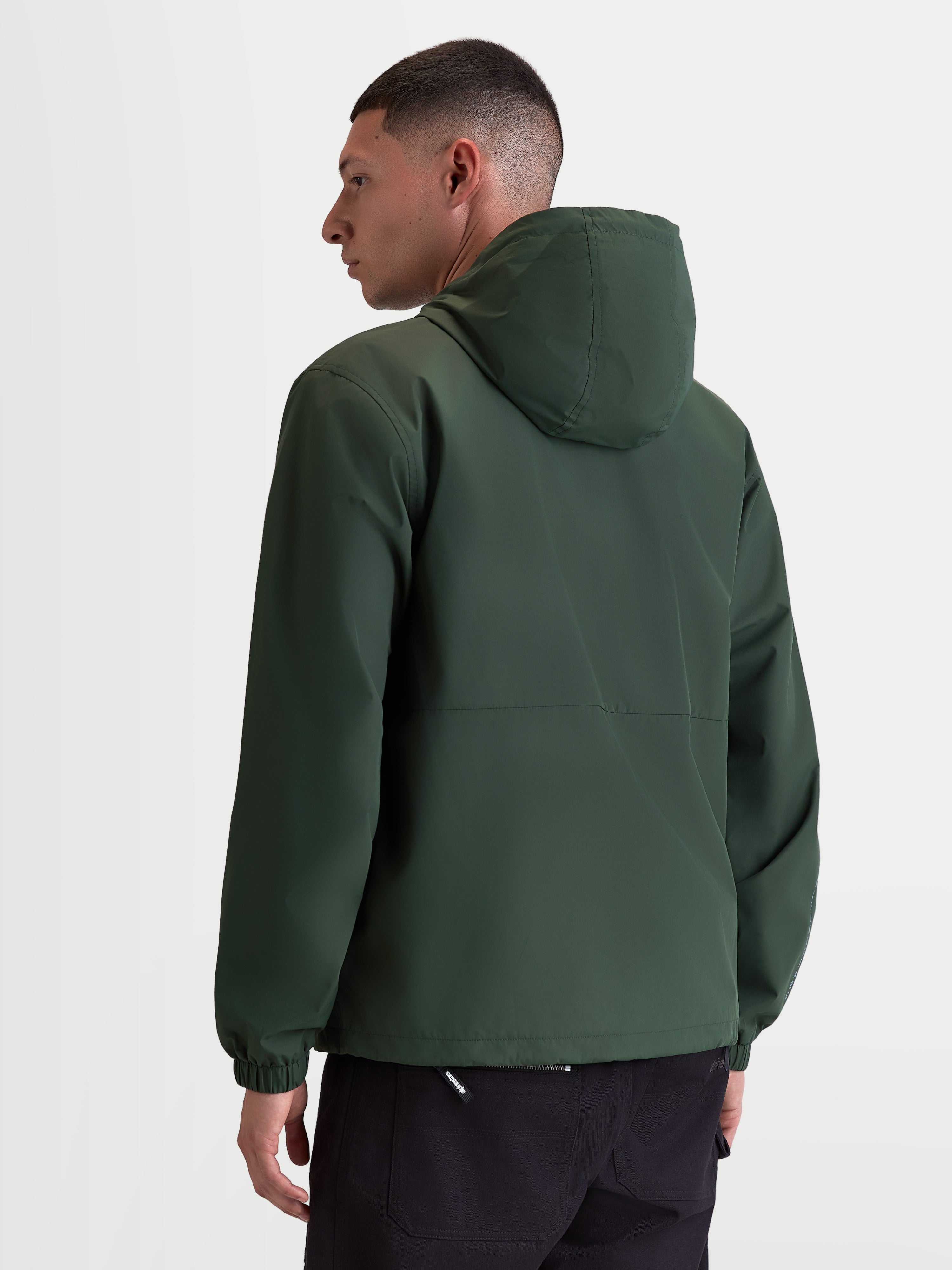Alpinestars Speeder Resolve vindstoppsjacka, lätt sportjacka för urban användning, grön, vindtät polyester med meshfoder, baksida på modell som visar den rena ryggdesignen och elastiska muddar.