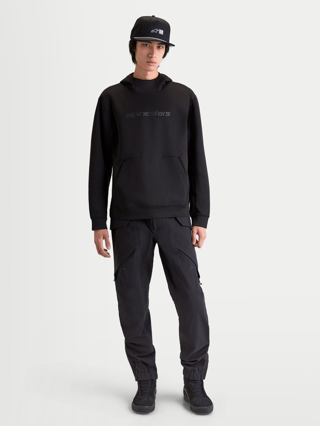 Alpinestars Datrix huvtröja, motorsportinspirerad huvtröja för herr, svart, med tonal HD-branding, meshfodrad huva och tri-blend fleece-konstruktion, avslappnad sportstil visad på modell.