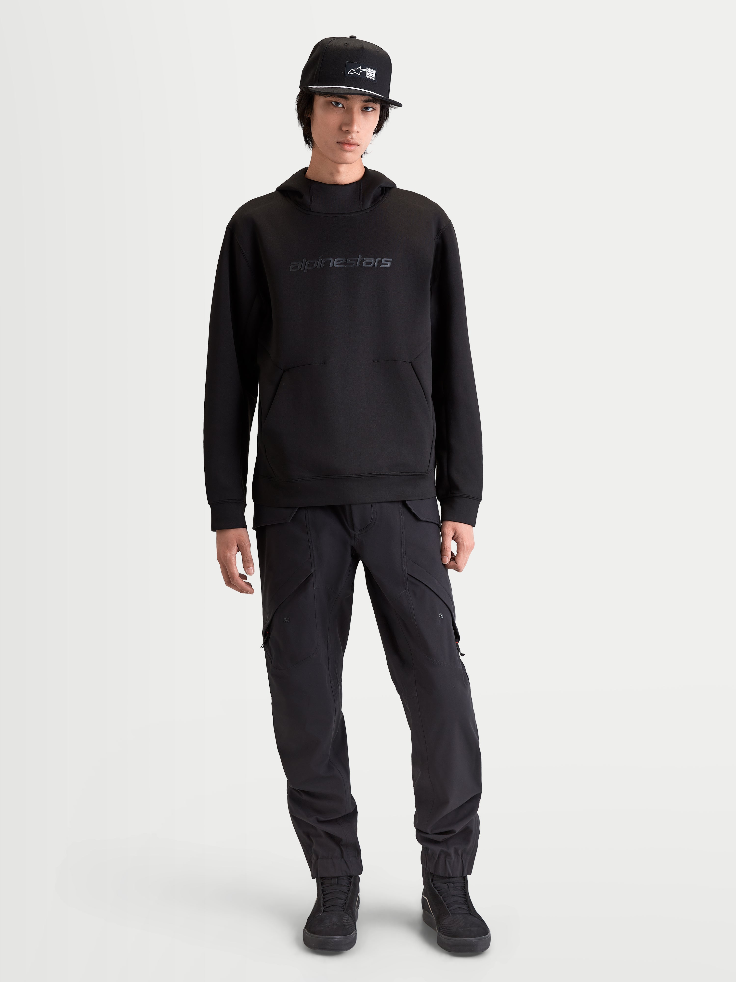 Alpinestars Datrix huvtröja, motorsportinspirerad huvtröja för herr, svart, med tonal HD-branding, meshfodrad huva och tri-blend fleece-konstruktion, avslappnad sportstil visad på modell.
