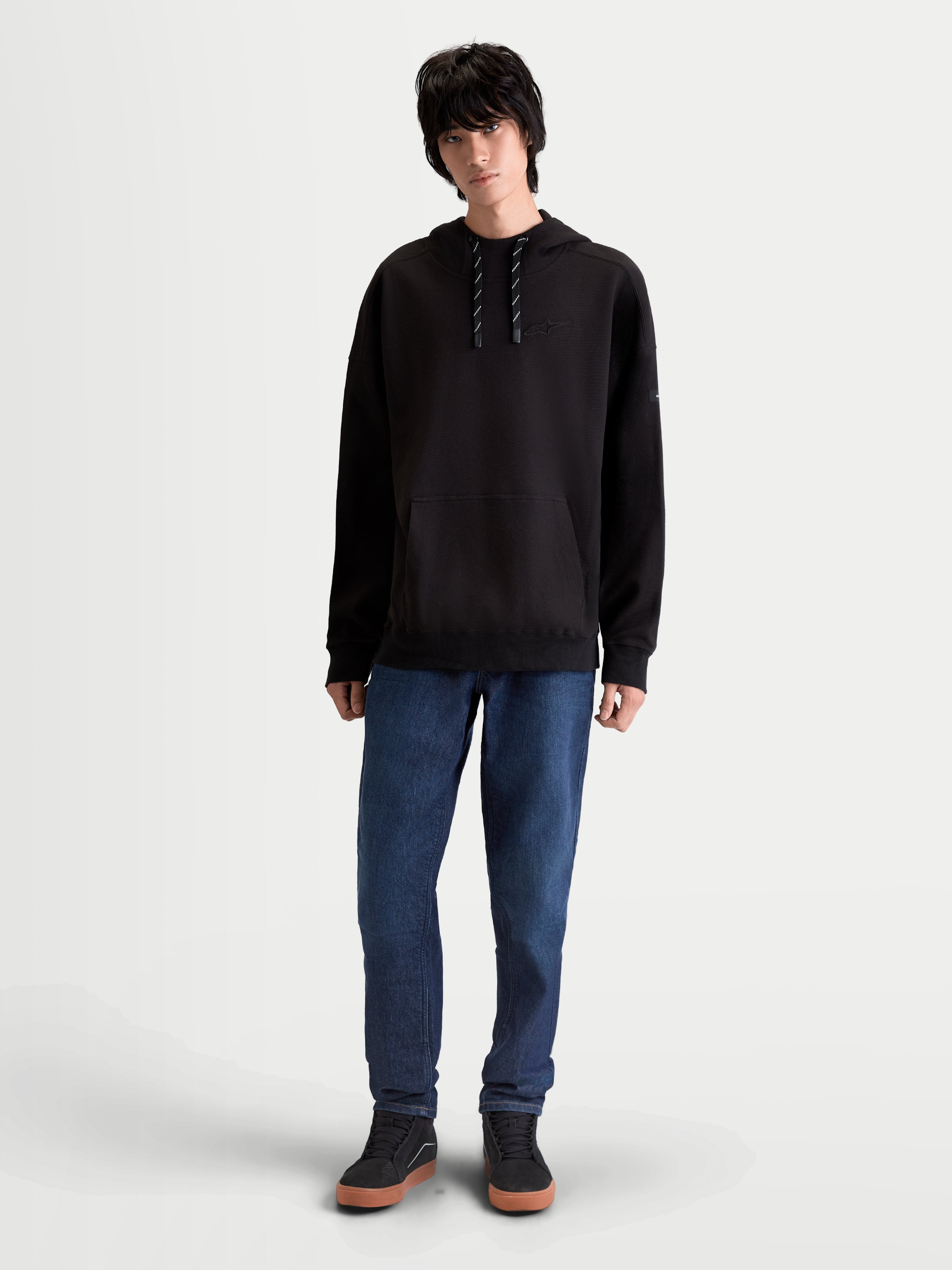 Alpinestars Camino Textured Oversized Huvtröja, herrhuvtröja för lifestyle och vardag, svart, texturerad stickad twillfleece med hög krage och känguruficka, avslappnad passform på modell.