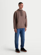 Alpinestars Camino Textured Oversized huvtröja, brun oversized huvtröja i texturerad stickad twillfleece med hög krage och känguruficka, avslappnad motorsportinspirerad design, visas på modell.