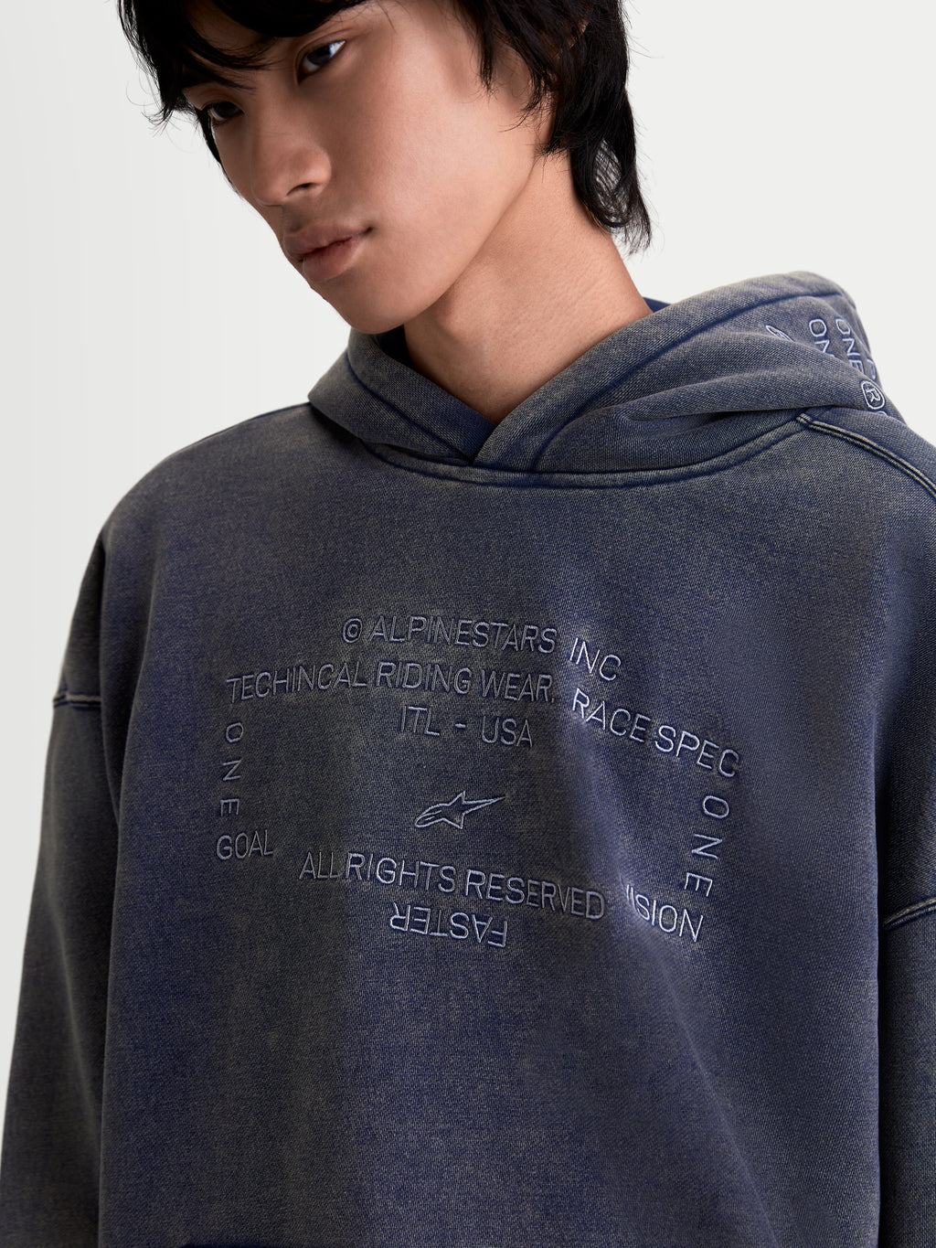 Alpinestars Infinite Washed Oversized Hoodie, Sportswear Pullover for Men and Women, Washed Navy Blue, featuring a snow-wash finish and detailed embroidered chest graphic with technical riding wear branding, oversized fit fleece construction.