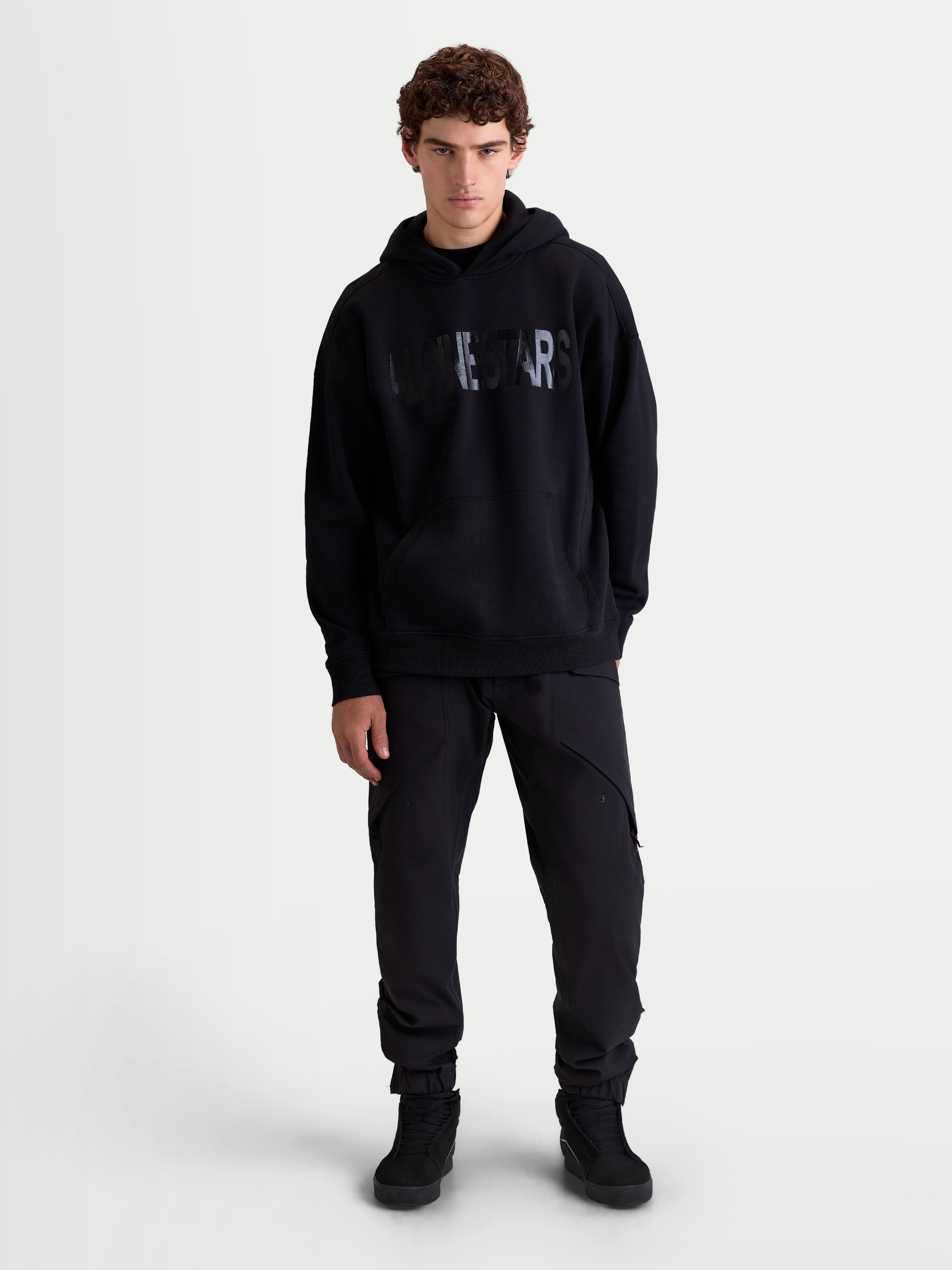 Alpinestars Shaw Oversized Hoodie, Men's Casual Sportswear Pullover in Black, Relaxed Fit Fleece featuring a textured Alpinestars word logo on chest, kangaroo pocket, and self-lined hood, front on-model view.