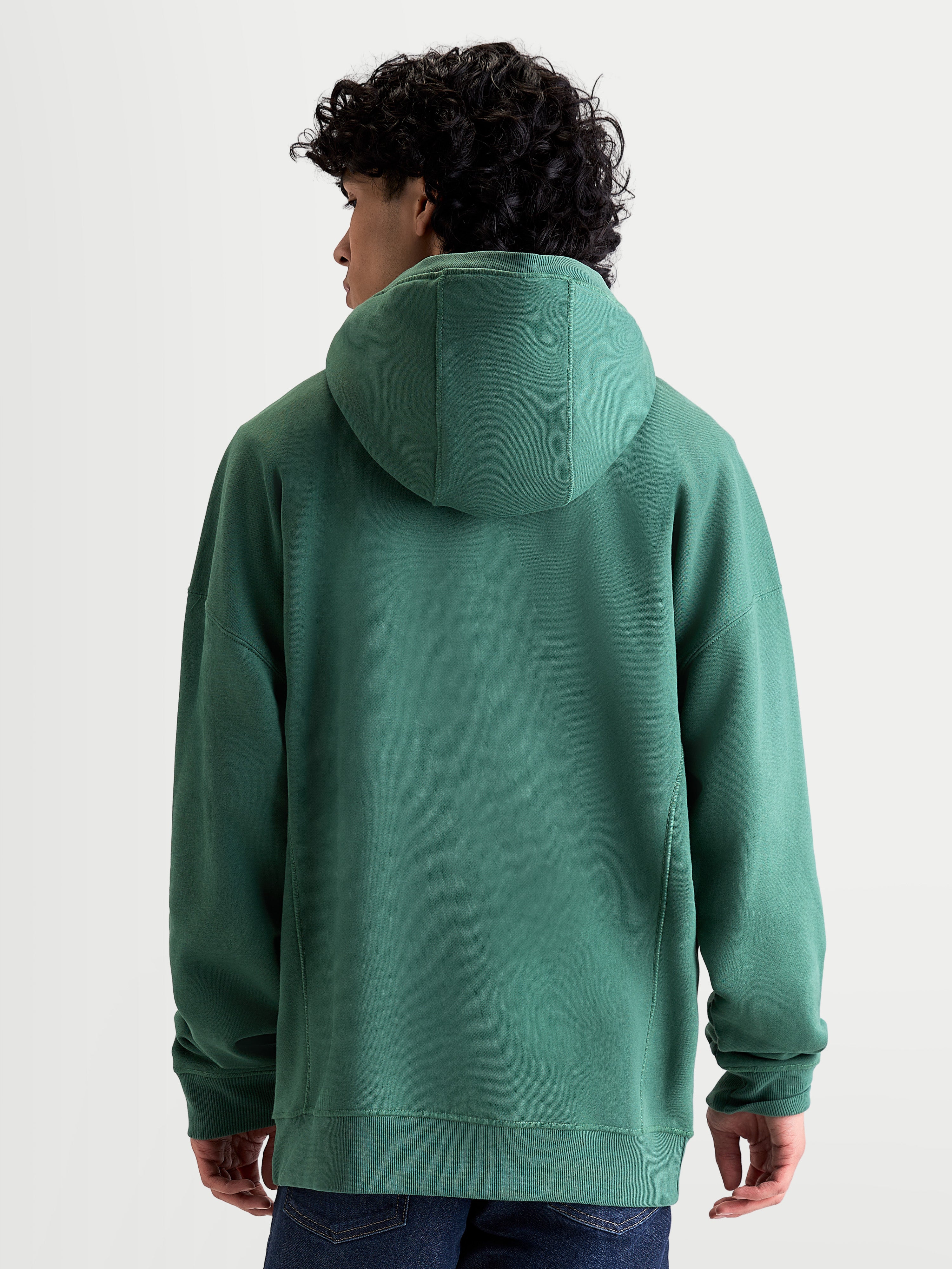 Alpinestars Shaw Oversized huvtröja, grön sportswear-pullover i fleece, unisex med avslappnad passform, sedd bakifrån på modell, ribbade avslut och huva, konstruktion i mjuk bomull och återvunnen polyester.