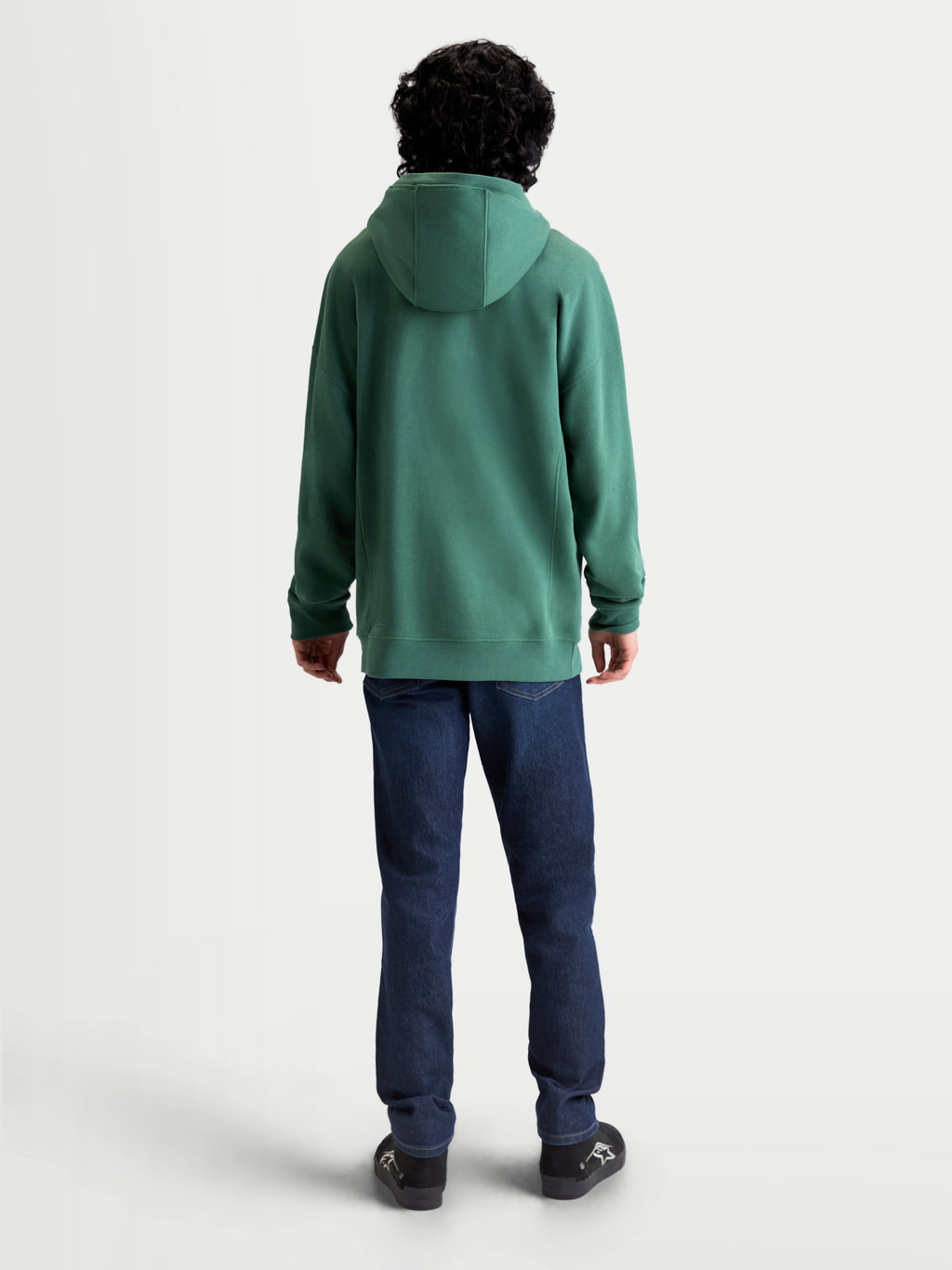 Alpinestars Shaw Oversized huvtröja, grön sportswear-huvtröja sedd bakifrån på modell, avslappnad unisex-passform, tillverkad i mjuk bomulls- och återvunnen polyesterfleece, självfodrad huva och ribbade avslut.