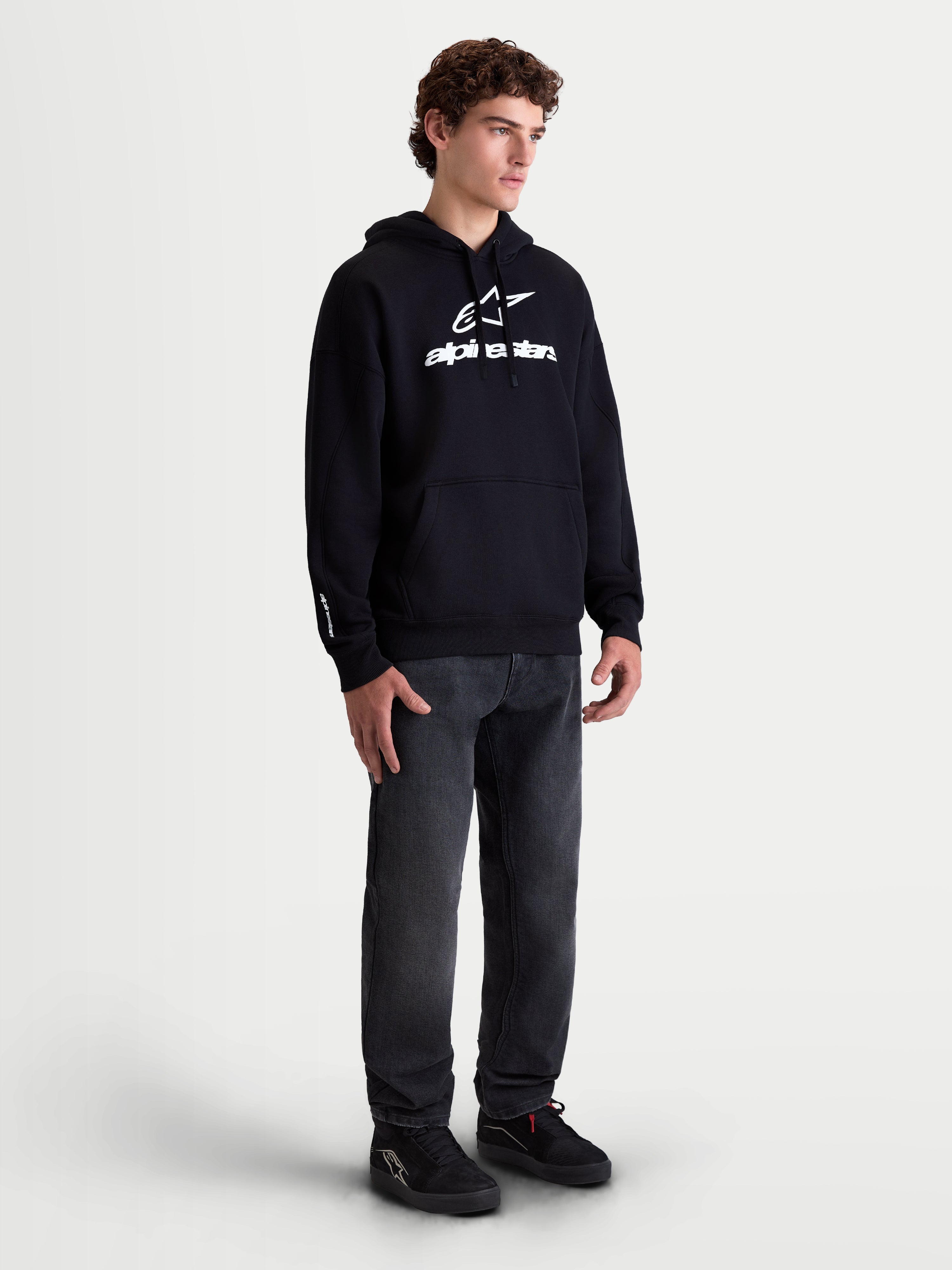 Alpinestars Prelude Oversized Hoodie, Men's Sportswear Fleece Pullover, Black with White puff-print logo, featuring a relaxed oversized fit and kangaroo pocket, shown on a model.