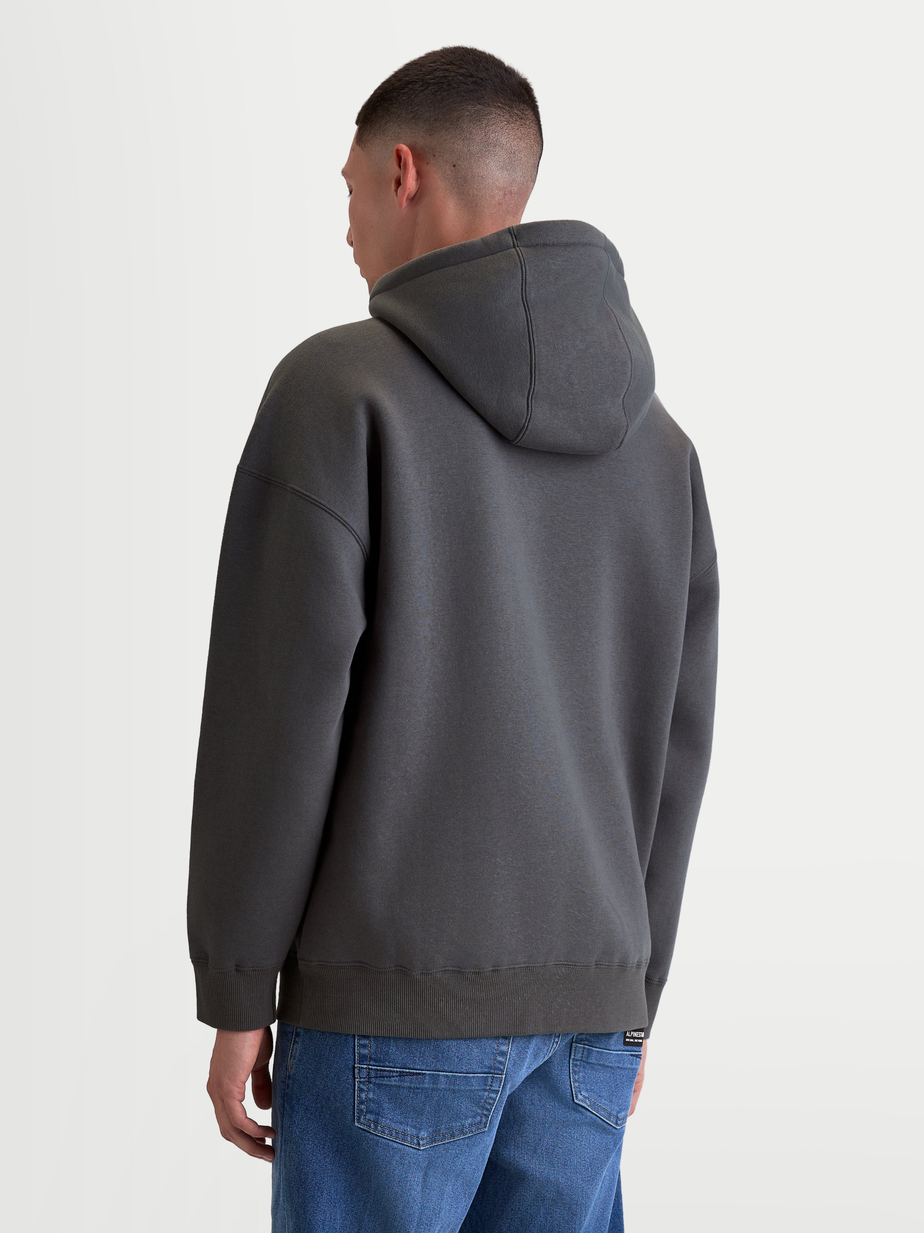 Alpinestars Prelude Oversized huvtröja, mörkgrå fleecehoodie för vardagsbruk, avslappnad oversized passform med självfodrad huva och ribbade muddar, vy bakifrån på modell.