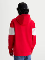 Alpinestars Cubic huvtröja, röd och vit sportswear-huvtröja i fleece, sedd bakifrån på modell med svart keps, färgblockerade ärmar, fodrad huva och ribbade muddar för en motorsport-inspirerad stil.