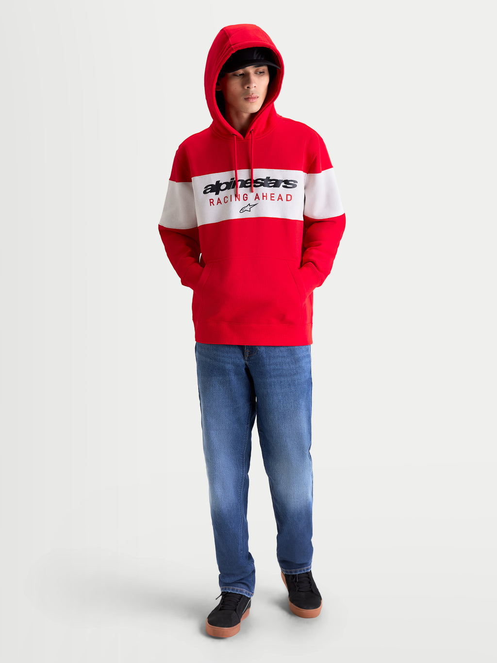 Alpinestars Cubic huvtröja, röd och vit färgblockerad huvtröja i mjuk fleece med Alpinestars Racing Ahead-logotyp på bröstet, avslappnad motorsportinspirerad stil på modell.