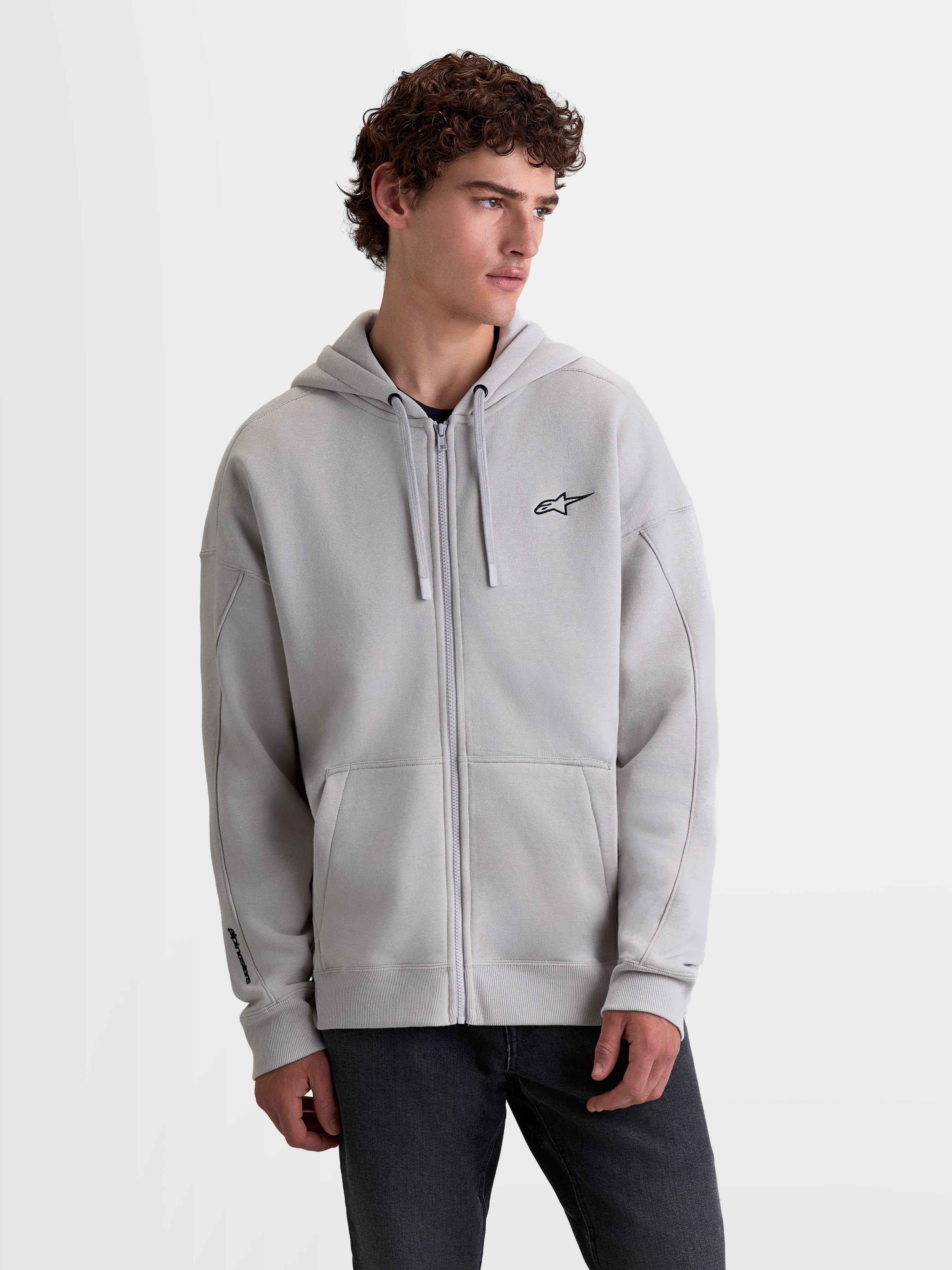 Alpinestars Entity Oversized huvtröja, grå huvtröja med dragkedja i mjuk fleeceblandning, broderad Astars-logotyp på bröstet, känguruficka och Vislon-dragkedja framtill, avslappnad oversized passform för vardagsbruk och sportig livsstil.