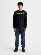 Alpinestars Velocifier CSF T-shirt, långärmad t-shirt, svart och gul, på modell, gult böjt Astars-tryck framtill, logotyper på axlarna och ribbade muddar, bekväm bomullsblandning för en motorsportinspirerad look.