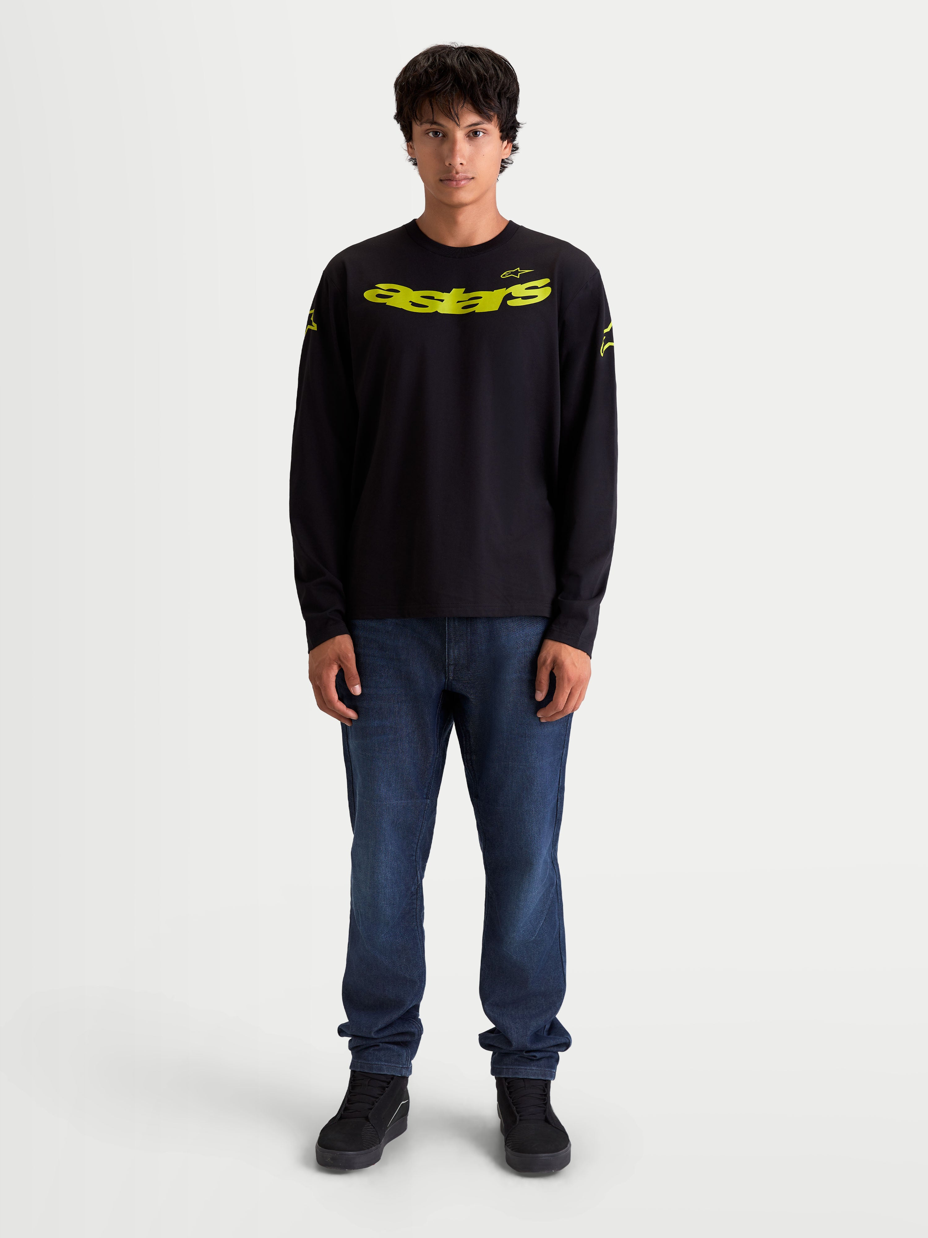 Alpinestars Velocifier CSF T-shirt, långärmad t-shirt, svart och gul, på modell, gult böjt Astars-tryck framtill, logotyper på axlarna och ribbade muddar, bekväm bomullsblandning för en motorsportinspirerad look.