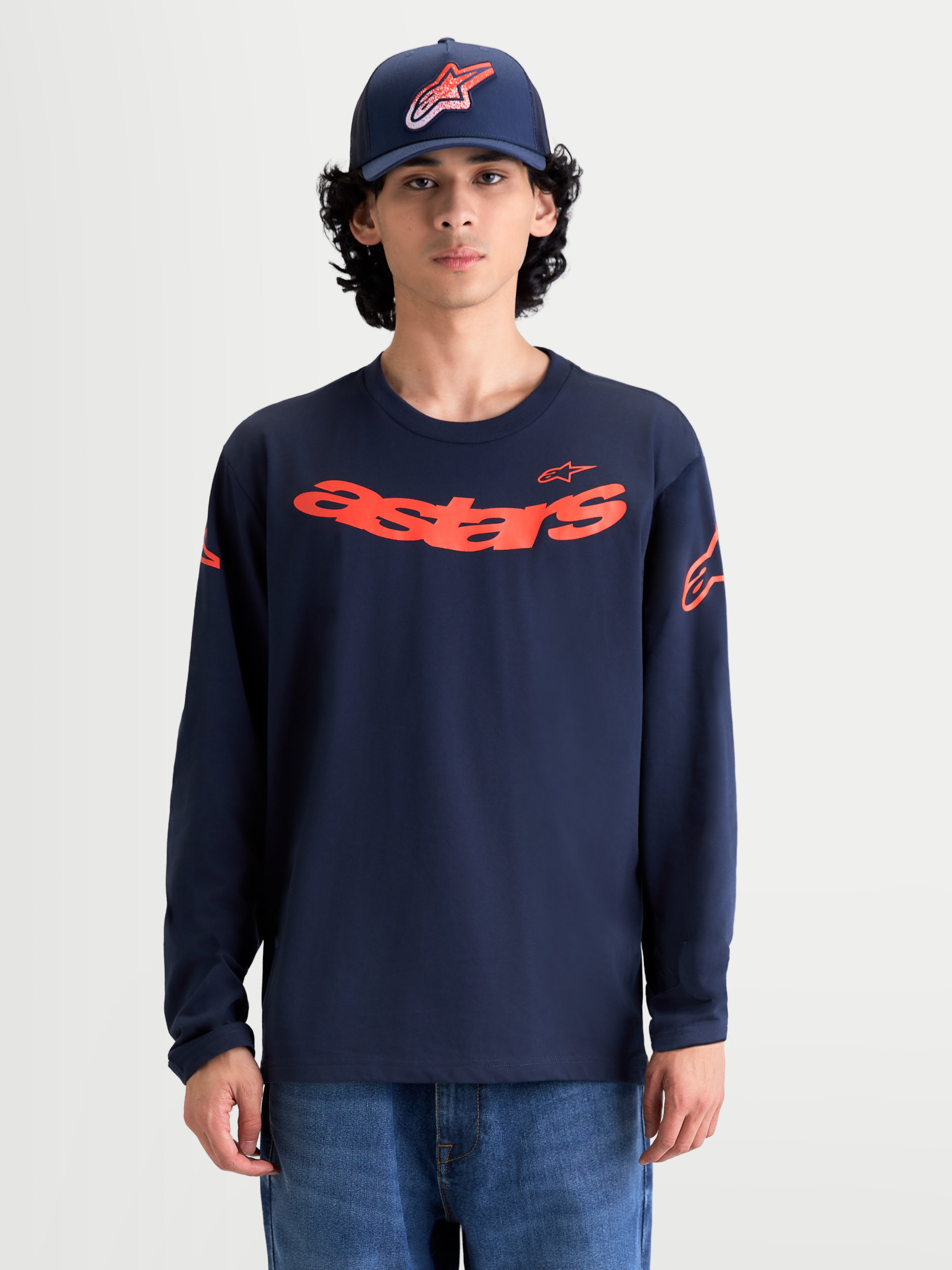 Alpinestars Velocifier CSF långärmad T-shirt, marinblå och orange sportswear-tröja på modell, böjt Astars-tryck på bröstet, axellogotyper och ribbade muddar, premium bomullsblandning för vardagskomfort.