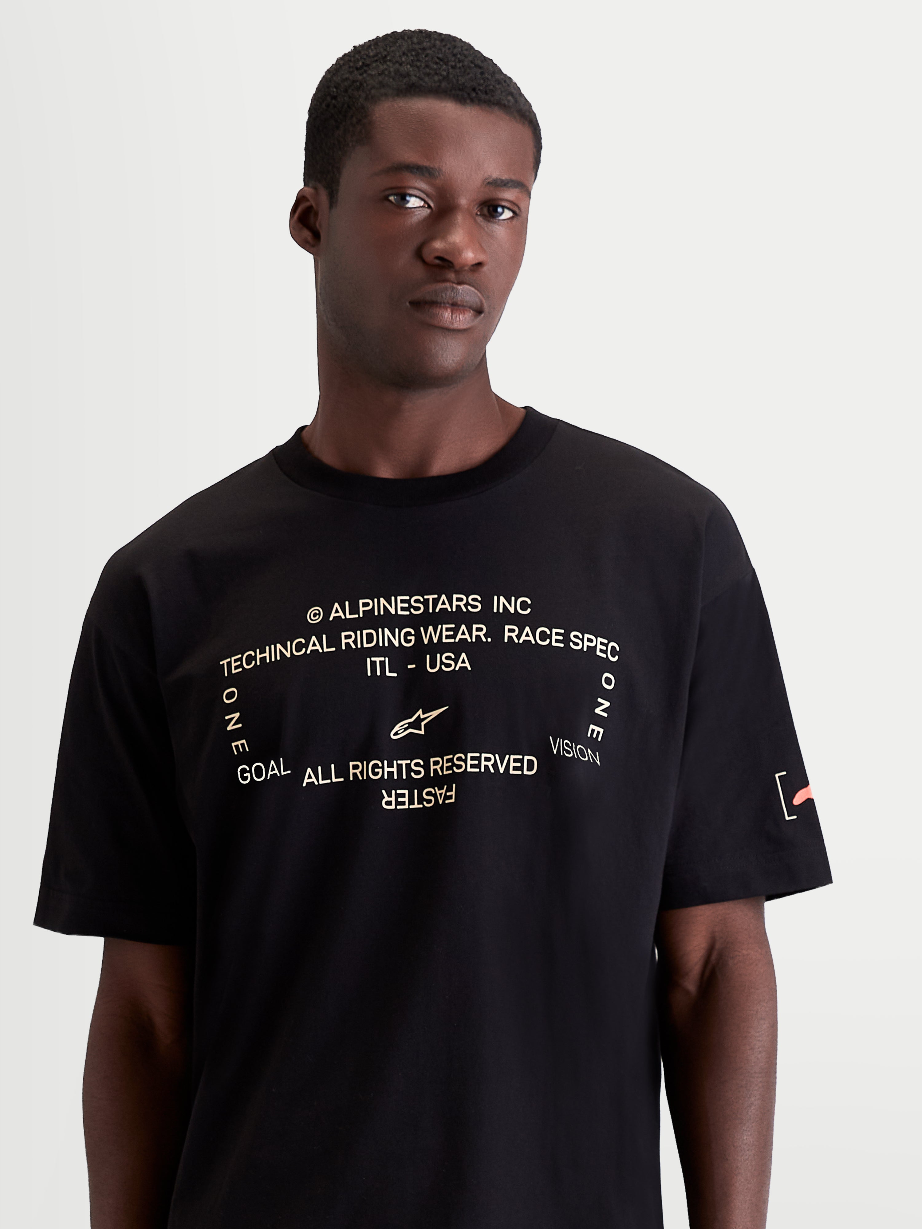 Alpinestars Infinity Oversized CSF t-shirt, kortärmad sportswear herr-t-shirt, svart med vit frontgrafik med texten 'One Goal. One Vision.', orange logodetalj på ärmen, oversized fit, avslappnad off-bike-stil.