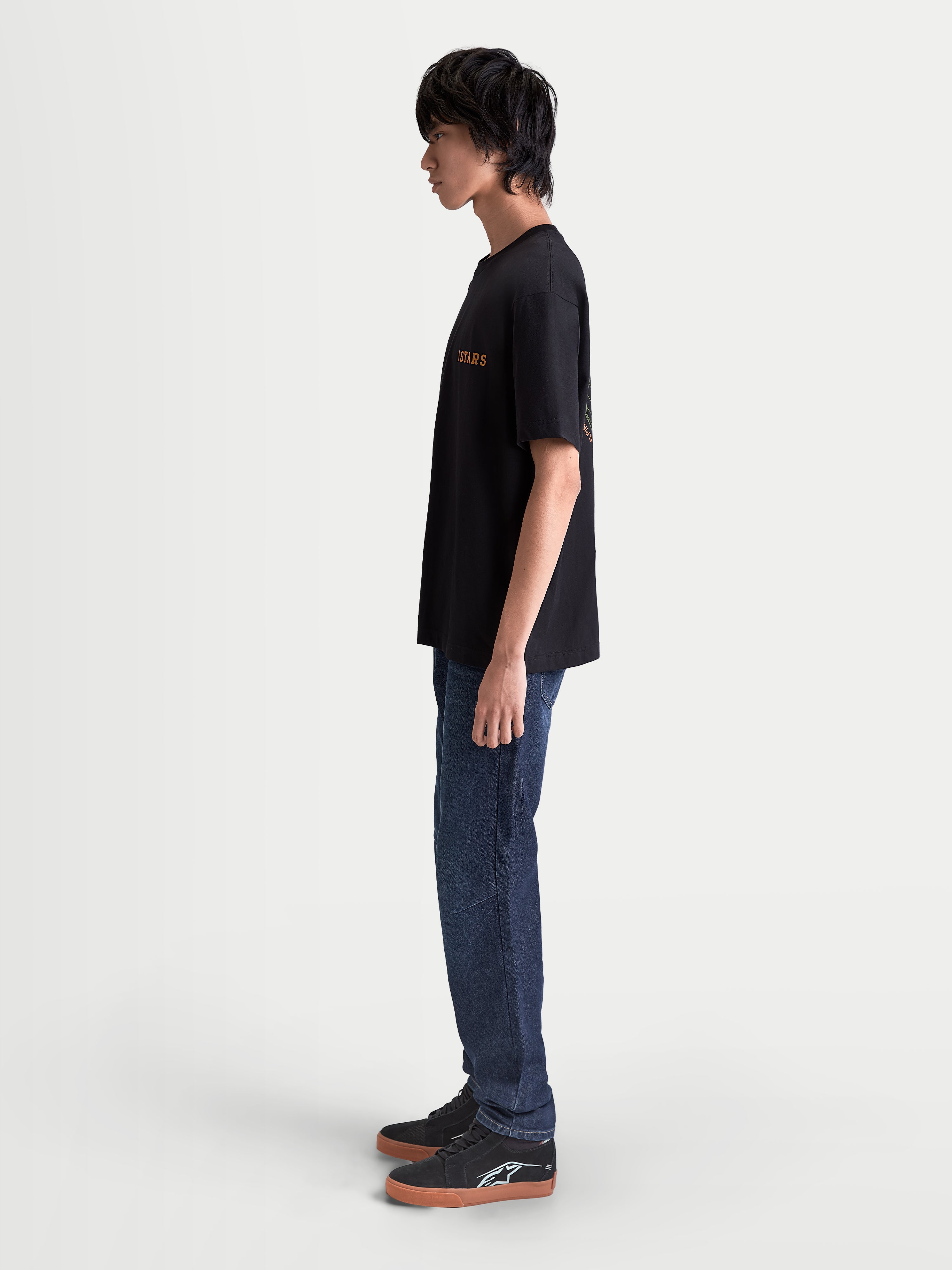 Alpinestars Latitude Oversized CSF t-shirt, svart kortärmad herrt-shirt med orange Astars-grafik, sidoprofil på modell, avslappnad oversized passform, casual sportswear för vardagsbruk