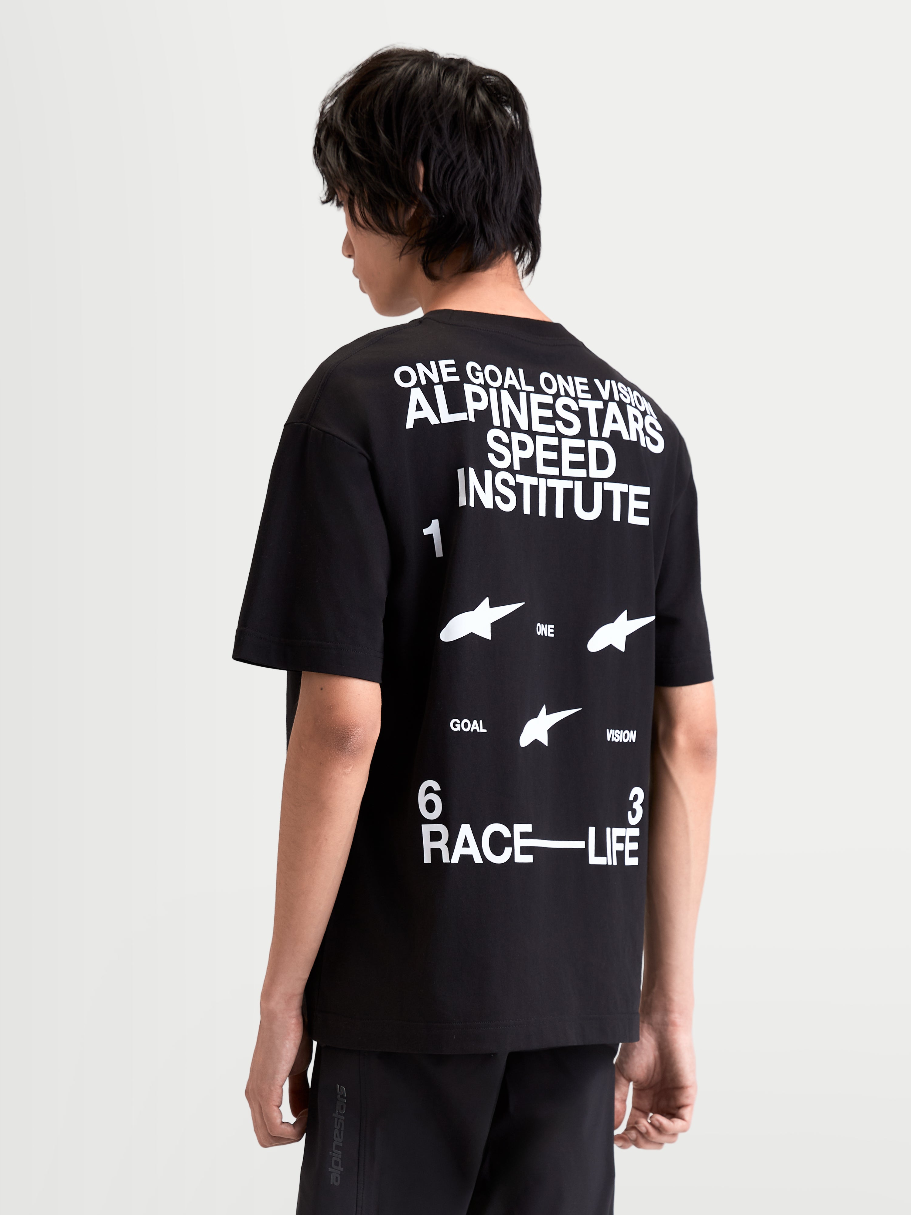 Alpinestars Institute Oversized CSF t-shirt, svart kortärmad t-shirt i oversized passform på modell, vy bakifrån med stor vit rygggrafik: One Goal One Vision Alpinestars Speed Institute och Race-Life, mjuk bomullsblandning.
