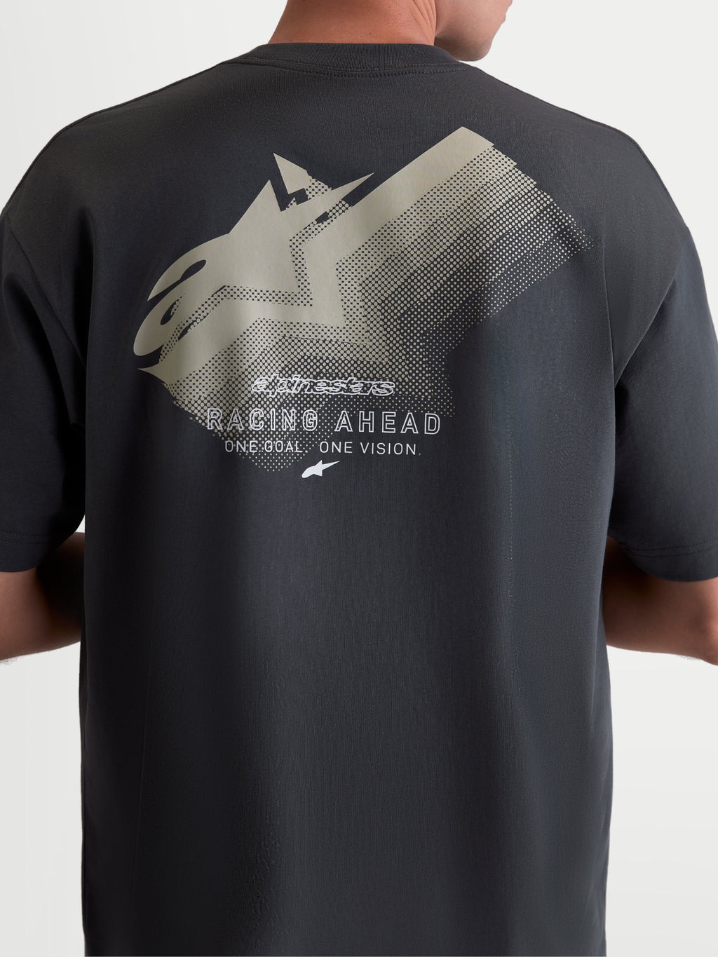 Alpinestars Ghost Oversized CSF t-shirt, mörkgrå kortärmad t-shirt i oversized silhuett, baksida på modell som visar en stor tonad logografik med texten Racing Ahead, mjuk bomulls-polyesterblandning, bekväm motorsport-streetwear.