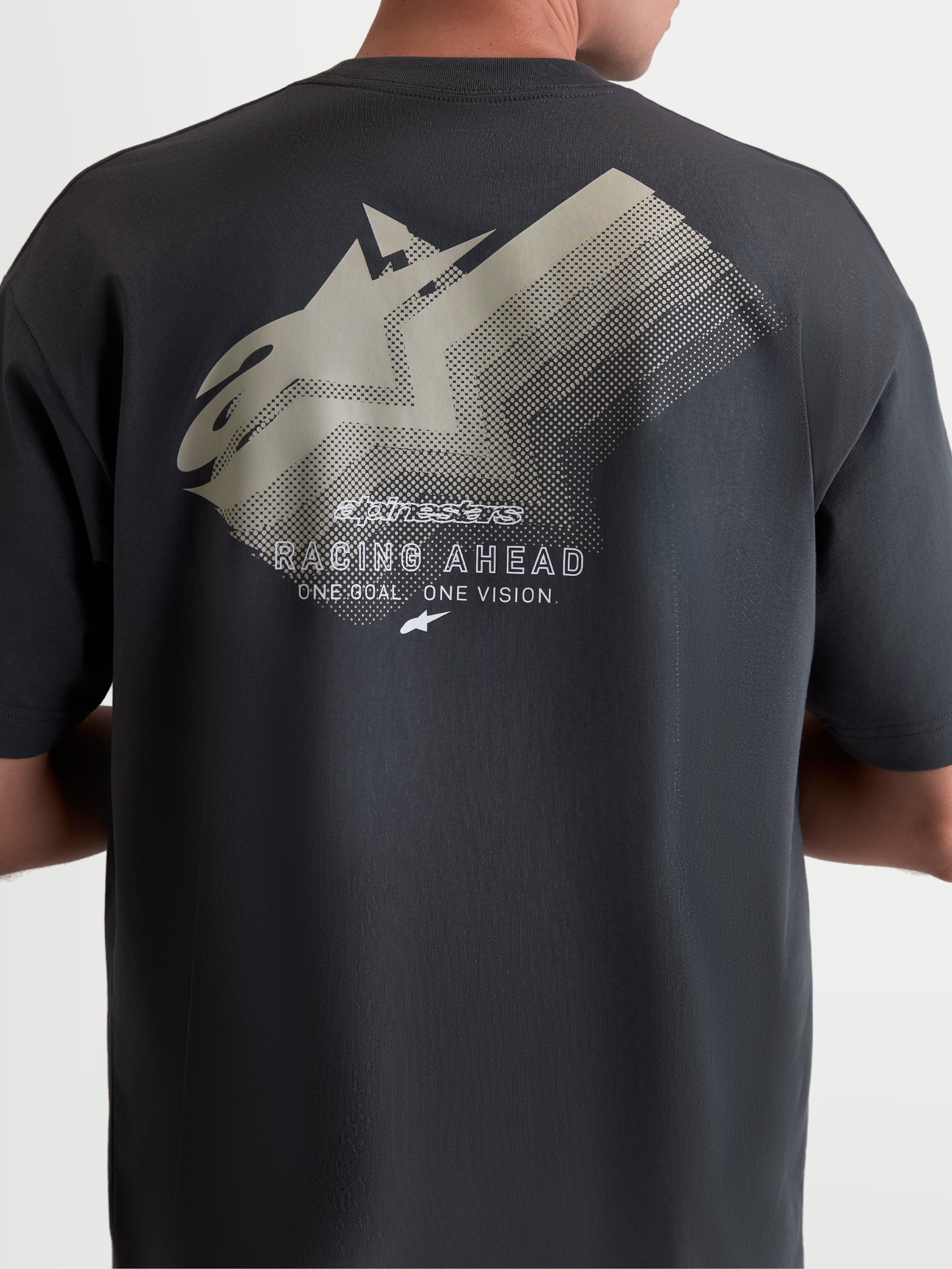 Alpinestars Ghost Oversized CSF t-shirt, mörkgrå kortärmad t-shirt i oversized silhuett, baksida på modell som visar en stor tonad logografik med texten Racing Ahead, mjuk bomulls-polyesterblandning, bekväm motorsport-streetwear.