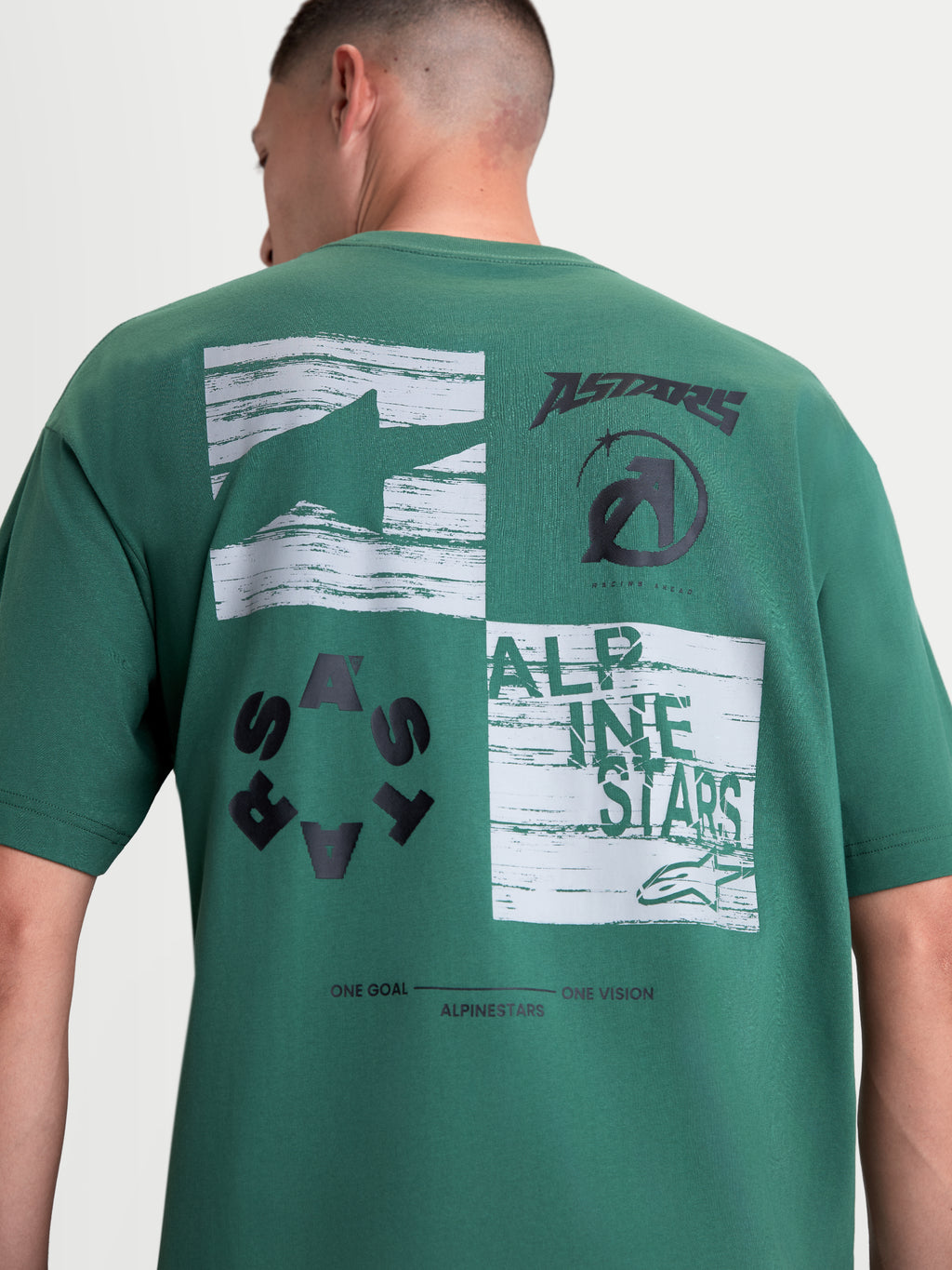 Alpinestars Checkback Oversized CSF t-shirt, grön kortärmad t-shirt i oversized passform sedd bakifrån med en tydlig rutgrafik och svarta Astars-logotyper på ryggen, motorsportinspirerad design.
