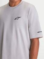 Alpinestars Mandate Oversized CSF t-shirt, kortärmad sportswear-modell för herr och dam, cementgrå med svart pufftryckt Astars-logotyp på bröstet och ordgrafik på ärmen, oversized passform för avslappnad komfort.