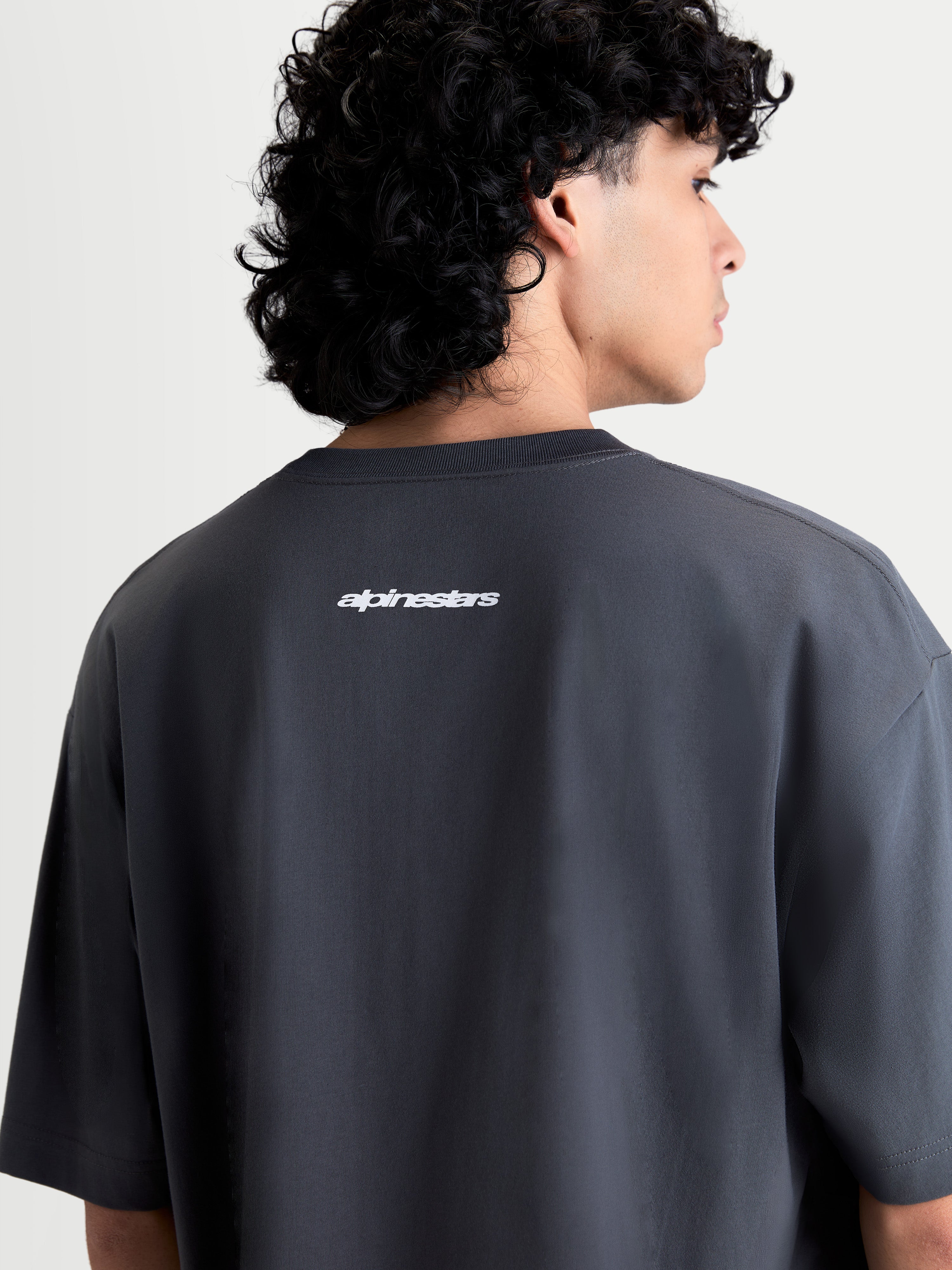 Alpinestars Mandate Oversized CSF T-shirt, grå kortärmad t-shirt med vit pufftryckt Alpinestars-logotyp på ryggen, avslappnad oversized passform, mjuk bomull-polyesterblandning.